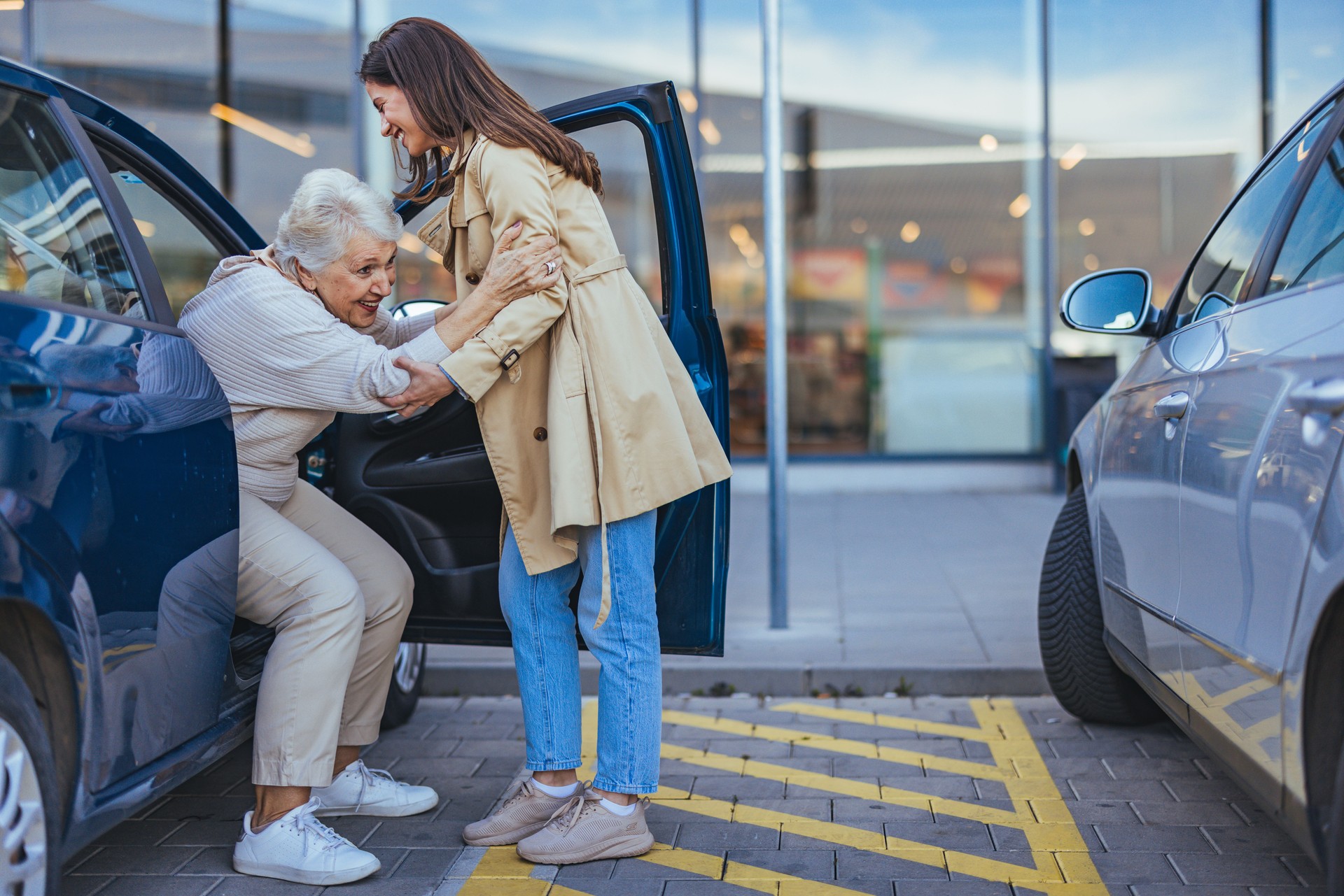 Young Woman Helping Elderly Woman Out Of Car